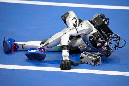 「世界人型ロボットスポーツ大会」でレースを終え、倒れるGMOインターネットグループのロボット=23日、北京(共同)