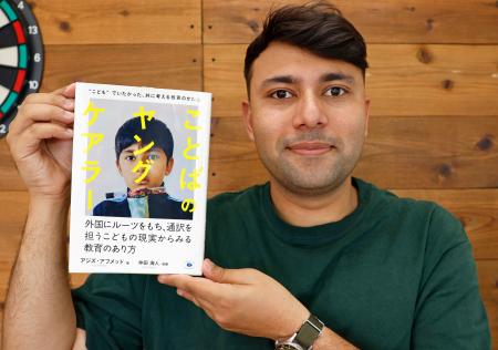 自著「ことばのヤングケアラー」を手に持つアジズ・アフメッドさん＝１４日、前橋市