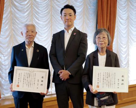 計４億円を大阪市に寄付した福西啓八さん（左）と昭代さん夫妻。中央は横山英幸市長＝２４日午後、大阪市役所