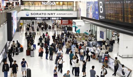 旅行客が行き交う成田空港の到着ロビー＝１６日