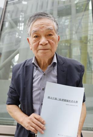 「三船遭難事件」の犠牲者名簿を手にする中尾則幸さん=7月、札幌市