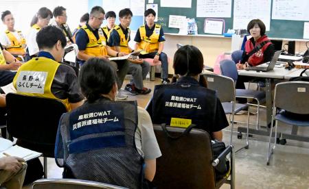 避難所で打ち合わせするＤＷＡＴの隊員ら＝２５日午後、熊本県氷川町
