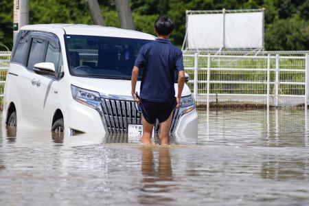大雨で冠水した千葉県大網白里市のコンビニの駐車場で立ち往生した車両＝１４日