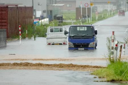 富山県氷見市の冠水した道路で水に漬かった車両＝２８日午前