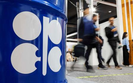 ＯＰＥＣのロゴと、付近を通る人々＝２０２４年１１月、アゼルバイジャン・バクー（ロイター＝共同）