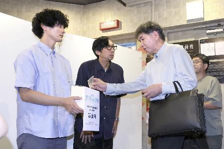 短編映画「うつくしいひと」のチャリティー上映会後、寄付を呼びかける（左から）俳優の高良健吾さんと行定勲監督＝３０日午後、東京都新宿区のテアトル新宿