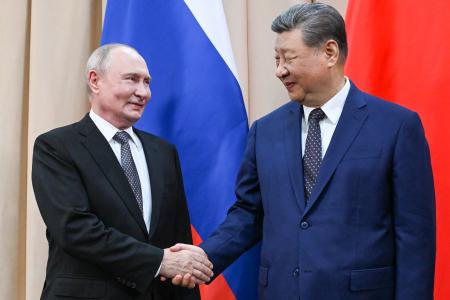 握手するロシアのプーチン大統領（左）と中国の習近平国家主席＝３１日、ビシケク（タス＝共同）