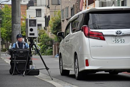 住宅街などの道幅が狭い「生活道路」で速度を取り締まる警察官＝１日午前、東京都江戸川区