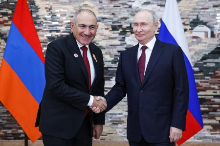 １日、キルギスの首都ビシケクで握手するアルメニアのパシニャン首相（左）とロシアのプーチン大統領（タス＝共同）