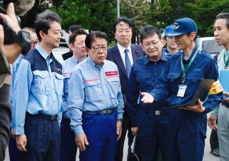 千葉豪雨で動かなくなり撤去された車両の仮置き場を視察する金子国交相（手前左から２人目）＝３日午前、千葉市