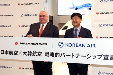 記者会見で写真に納まる日航のレゲット・ロス専務（左）と大韓航空の崔晶皓副社長＝３日午後、東京都内