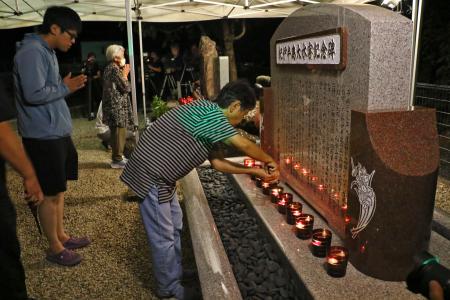 紀伊半島豪雨から１５年、キャンドルをともし手を合わせる遺族ら＝４日未明、和歌山県那智勝浦町