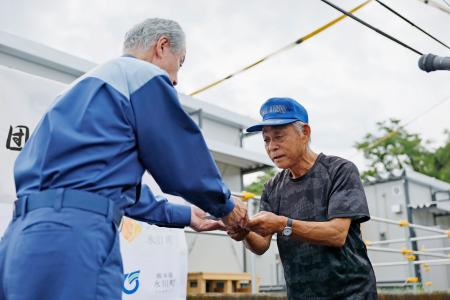 　熊本県氷川町に完成した仮設住宅の鍵を受け取る入居者＝５日午前