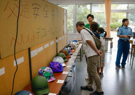 香川県立三本松高校で開かれたコンテストで、色とりどりのヘルメットを見比べる来場者＝５日午後、香川県東かがわ市