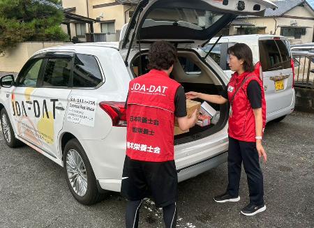 被災者支援に向かうため食料などを車に積み込むJDA―DATの隊員=5日、熊本市(熊本県栄養士会提供)
