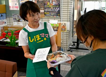 熊本県氷川町役場でひとり親に弁当を手渡す柳原志保さん＝８月