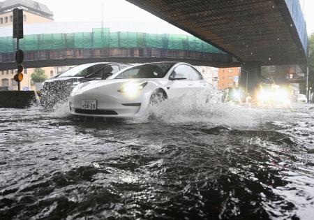 大雨で水があふれた名古屋市中区の道路。車がしぶきを上げながら行き交った＝８日午後４時１９分