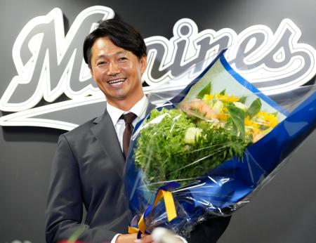 記者会見を終え、花束を手に笑顔を見せるロッテ・唐川＝８日、ＺＯＺＯマリン
