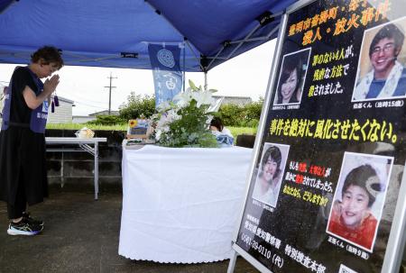　母子４人殺害事件から２２年となり、献花台に手を合わせる天海としさん＝９日午後、愛知県豊明市