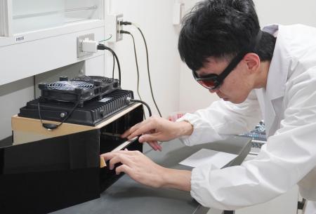 鮮やかな「白色」の材料を印刷する技術を実演する研究チーム員=9日午後、京都市