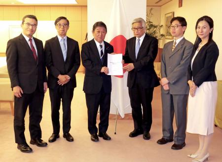 茂木外相（中央左）に提言を渡す県公一郎早大名誉教授（同右）ら＝１０日午後、外務省