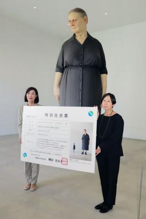 女性像「スタンディング・ウーマン」に授与した特別住民票とともに写真に納まる青森県十和田市の桜田百合子市長（左）と市現代美術館の四方幸子館長＝１１日午後、青森県十和田市