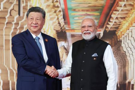 ＢＲＩＣＳ首脳会議のため、到着した中国の習近平国家主席（左）と握手するインドのモディ首相＝１２日、ニューデリー（インド外務省提供・ＡＰ＝共同）