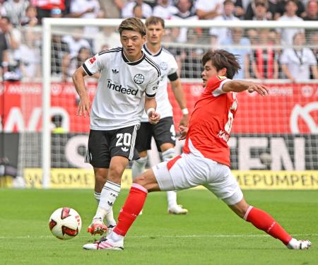 競り合うＥフランクフルトの堂安（左）とマインツの佐野海＝マインツ（共同）