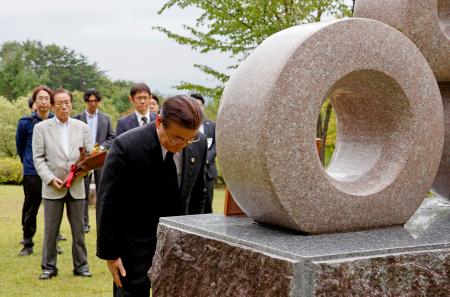 坂本堤弁護士一家の慰霊碑に献花し、一礼する日弁連の松田純一会長（手前）＝１３日午前、長野県大町市