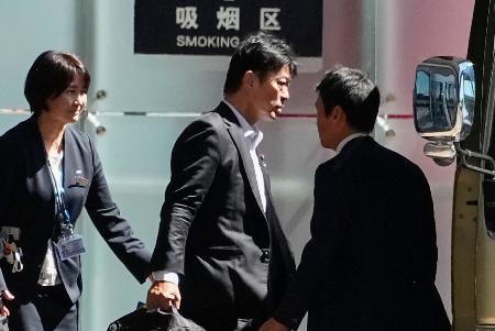 北京の空港に到着した日中友好議員連盟の高村正大・前法務副大臣（中央）＝１３日（共同）