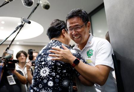 沖縄県知事選で初当選を決め、祝福される古謝玄太氏=13日夜、那覇市