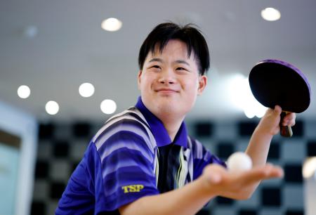 卓球のラケットとボールを手にポーズをとる中村遼介さん＝８月、名古屋市