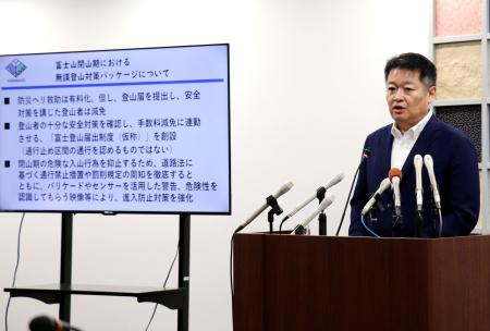 記者会見で、県防災ヘリコプターの救助費の有料化を表明する山梨県の長崎幸太郎知事＝１４日午後、県庁