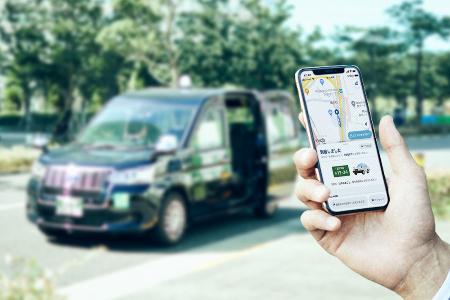 「GO」が展開するタクシー配車アプリのスマートフォン画面(手前)と対応車両
