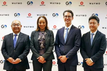 完全無人タクシーの運行発表の記者会見に出席した、ウェイモのテキドラ・マワカナCEO(左から2人目)、GOの川鍋一朗会長(同3人目)ら=15日午前、東京都千代田区