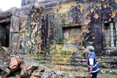 世界遺産のヒンズー教寺院遺跡「プレアビヒア」で、砲撃による被害を指さす当局者＝１０日、カンボジア北部（共同）