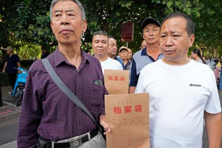 訴状の入った袋を持ち、高級人民法院に向かう日中戦争時の強制連行の中国人被害者遺族ら＝１６日、中国河北省石家荘市（共同）
