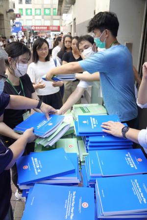 香港の街頭で配布される「５カ年計画」の冊子＝１６日（共同）
