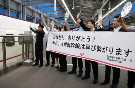 鹿児島中央駅で、始発の九州新幹線を見送る駅員ら＝１８日午前