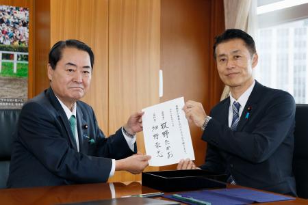 牧野前復興相(左)から引き継ぎを受ける細野復興相=18日午前、復興庁