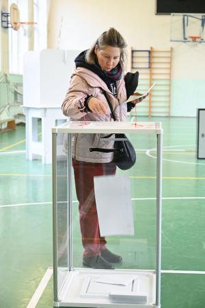 １８日、モスクワ中心部でロシア下院選の投票をする女性（共同）