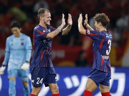名古屋に競り勝ち、森重（右）とタッチを交わすＦＣ東京・ショルツ＝ＭＵＦＧ国立