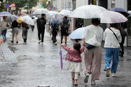 雨の中を歩く人たち＝２０日午後、千葉市