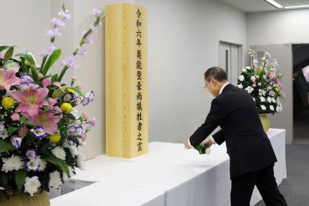 石川県庁に設置された献花台に花を手向ける山野之義知事＝２１日午前
