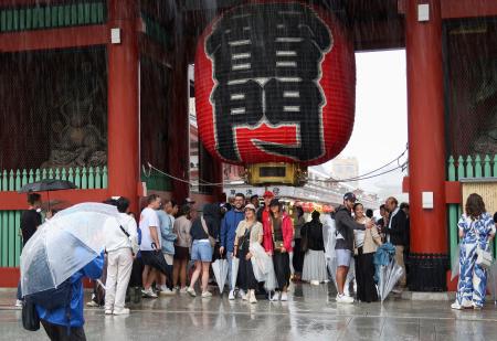 浅草寺雷門の下で雨宿りする観光客ら＝２１日午前９時１５分、東京都台東区
