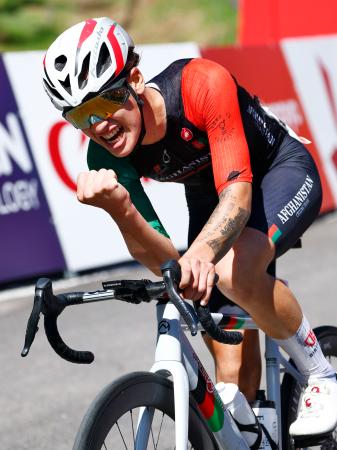 自転車女子個人ロードレースを２位でゴールし、ガッツポーズするアフガニスタンのファリバ・ハシミ＝２２日、新城市内特設コース