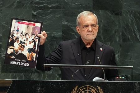 ２３日、国連総会一般討論で、写真を手に演説するイランのペゼシュキアン大統領＝米ニューヨーク（ＡＰ＝共同）