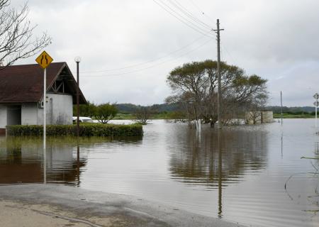 印旛沼の決壊で浸水した道路＝２４日午前９時３８分、千葉県成田市