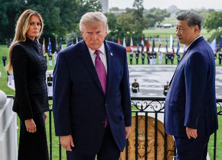 ホワイトハウスのバルコニーを後にするトランプ米大統領(中央)と中国の習近平国家主席(右)=24日、ワシントン(ロイター=共同)