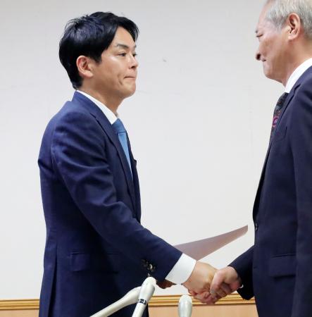 横浜市長選への出馬要請を受け、握手を交わす山中竹春前市長（左）＝２５日午後、横浜市